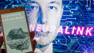 hand holds up phone with the Neuralink website displayed on its screen. In the background, an edited photo of Elon Musk's face with the word "Neuralink" superimposed over it can be seen 